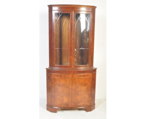 A 20th century George III burr walnut corner cabinet / display vitrine raised on bracket feet. Having twin glazed doors atop 