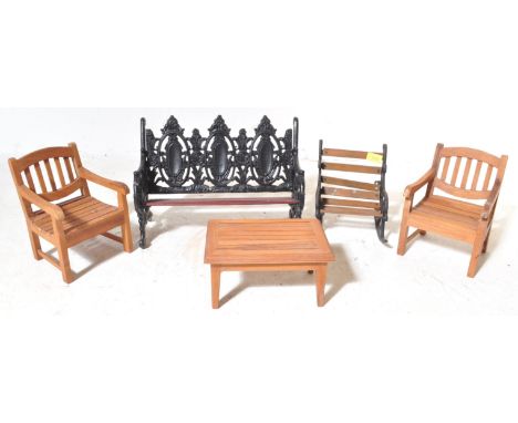 A collection of vintage 20th century miniature apprentice garden furniture to include wooden seats and tables alongside a Coa