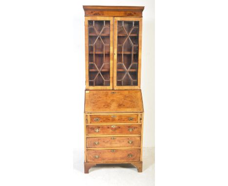 A Queen Anne revival yew wood and walnut bureau bookcase. Raised on bracket feet with drawers and fall front bureau having ap