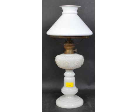A Victorian 19th century oil lamp having an opaline stepped base with reservoir having impressed floral motifs. Measures 47cm