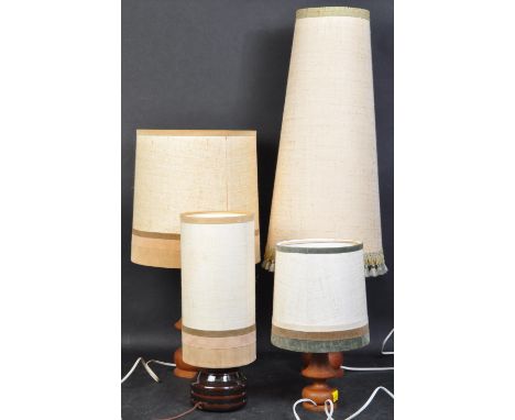 A set of four retro vintage mid 20th Century teak table lamps. All with various sized light shades, in circular form, and tur