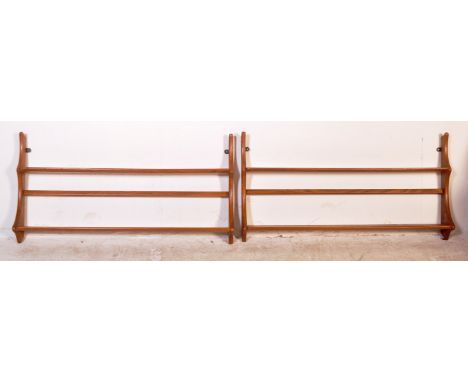 A pair of vintage retro mid 20th century Ercol book racks / wall hanging shelves, each having a series of two shelves. Measur