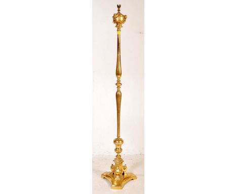 A vintage 20th century brass standard lamp having a single column decorated with cherubs heads raised on a tripod base. Measu