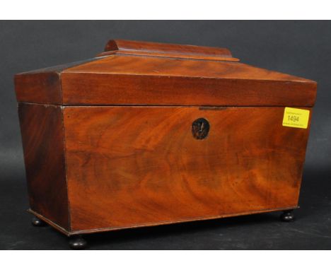 A 19th century flame mahogany tea caddy of rectangular form with sarcophagus type lid having canted sides and dome top handle
