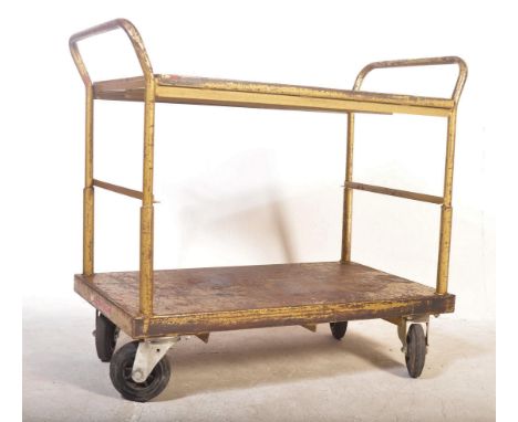 A retro vintage 20th century Industrial factory workshop trolley having two tiers with raised side set upon castors. Measures