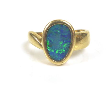 A 14k yellow gold and opal ring, the oviform shaped opal in rub over setting, 10.5 by 7.0mm, on wide tapering band, size K, 3