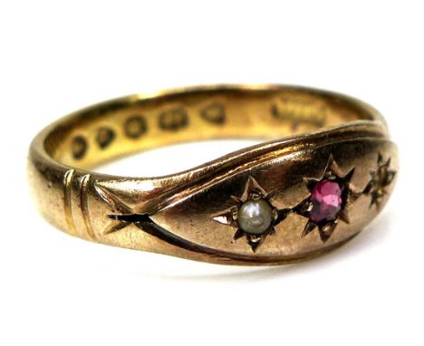 A Victorian 22ct yellow gold, ruby, and pearl ring, the central cushion cut ruby 2.3 by 1.3mm, flanked by a seed pearl (a/f t