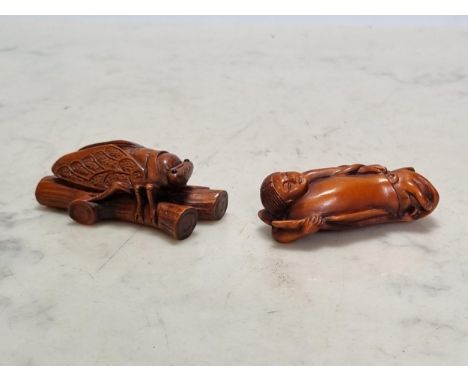 Two Oriental carved wood Netsuke, a Cicada on a branch, bears signature, 2 1/2in and a Figure, 2 1/4in  Small hair crack to t