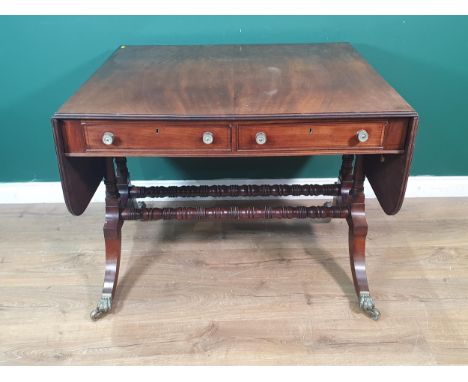 A Regency mahogany Sofa Table in the manner of Gillows fitted two frieze drawers on twin turned column supports with down swe