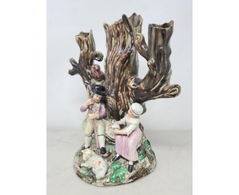An early Staffordshire figure group of shepherd and shepherdess with pair of sheep, sat at the base of a tree trunk with owl 