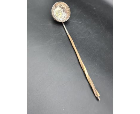 A Georgian Toddy Ladle with floral embossed and coin inset circular bowl, spiral handle 