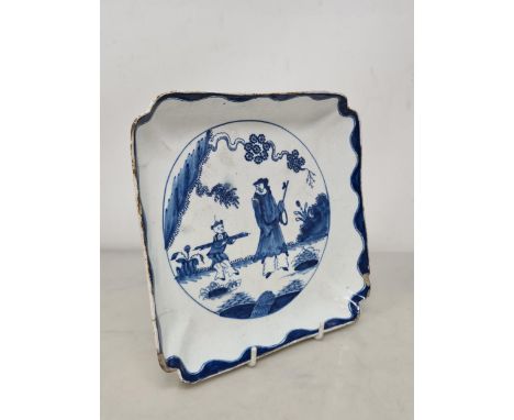 An 18th Century bow porcelain 'Golfer and Caddy' pattern square Dish with shaped rim, and blue wavy border, A/F, 7 1/2in x 7 