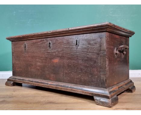 A late 17th Century oak Strong Box with hinged lid above three locks and riveted heavy duty strap hinges raised on bracket fe