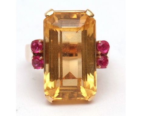 Modern yellow metal large citrine and small ruby dress ring, the large rectangular stepped cut citrine 20 x 10mm, basket set 