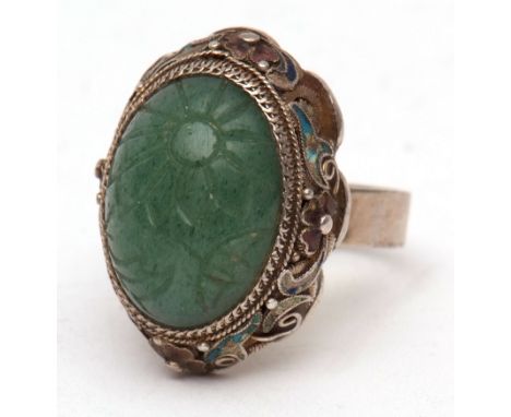 Early 20th century Chinese jade and enamel ring, the cabochon oval jade panel engraved with a flower in a filigree mount with