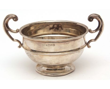 Edward VII two-handled sugar basin, of girdled circular form with flying C-scroll handles and raised on a spreading circular 