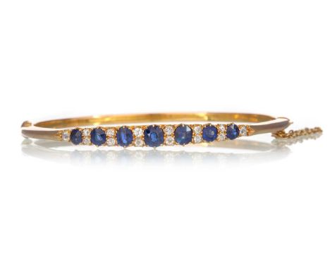 SAPPHIRE AND DIAMOND BANGLE, the sapphires interspaced by pairs of diamonds, marked 15CTQty: 9.8gGenerally worn. Scratches et
