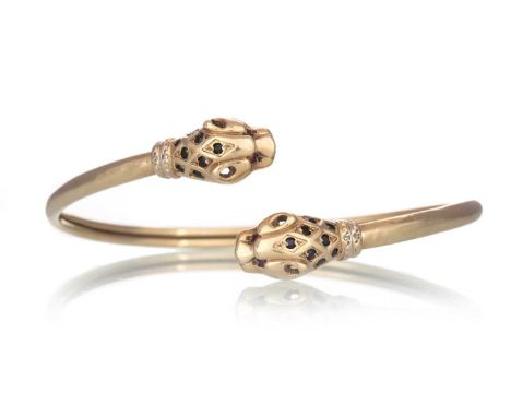PANTHER HEAD TORQUE BANGLE, the panther heads set with sapphires, ruby eyes and amall diamond chips to the collar, in nine ca