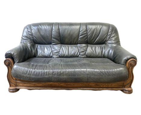A modern leather and beech framed sofa, with padded back and seat and scroll faced arms.