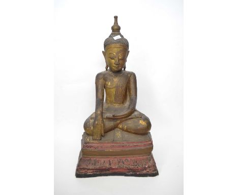 A 19th century wooden model of buddha with painted decoration in typical pose seated on a shaped wooden base86cmsome wear and