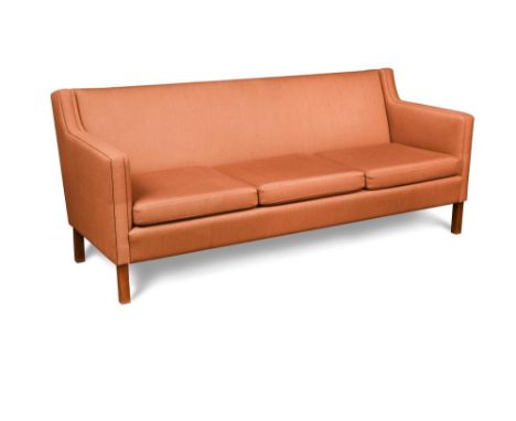 In the manner of Børge Mogensen, a 1960's Danish three-seater sofa, upholstered in salmon pink wool and raised on square feet