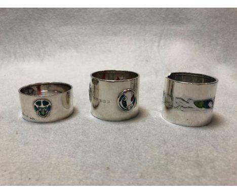 Liberty & Co., two silver and enamel napkin rings and another by William H. Haseler, variously cast and enamelled with stylis