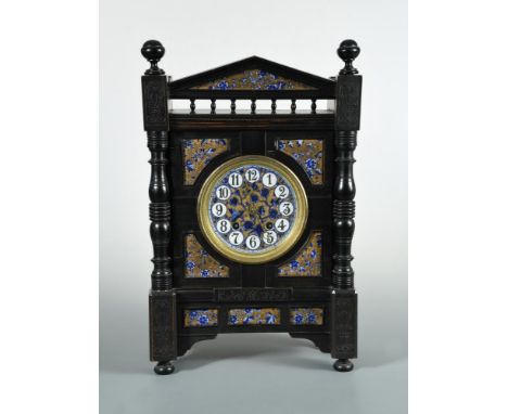 Attributed to Lewis Foreman Day, an Aesthetic movement ebonised striking mantle clock, circa 1880, the circular face painted 