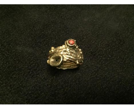 § Gerda Flöckinger, CBE, (born 1927), a gemset ring, the small round red hardstone cabochon set amongst organically textured 