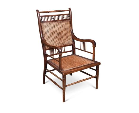 Attributed to E. W. Godwin, a mahogany elbow chair, with turned top rail above the spindle gallery rail over the caned back a