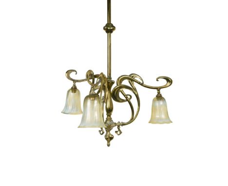 An Art Nouveau brass ceiling light with vaseline glass shades, the brass hanging rod supporting three scrolling foliate arms 