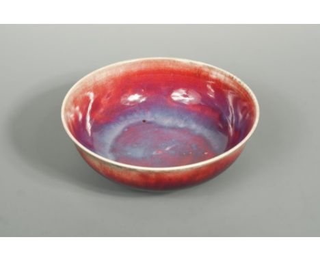 A Ruskin high-fired flambé bowl, 1924, the circular bowl with slightly flared rim raised on a foot with clouded red-purple fl