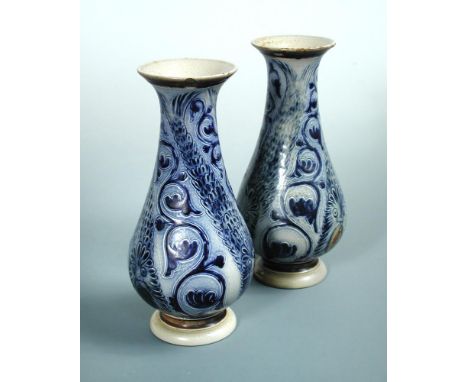 A pair of Martin Brothers vases, each of baluster form with flaring rim and decorated in blue tones with mythical beasts and 