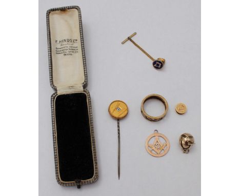 An assortment of gold, silver and yellow metal Masonic jewellery items including a ring, a diamond tie pin, a pendant and stu