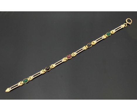 A 9ct gold bracelet modelled as five oval cabochon cut stones of emerald, ruby and sapphire colour, linked by twin white-gold