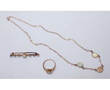 An unmarked gold bar brooch set to the centre with a round opal, measuring 7.23mm, and further flanked along the bar with six