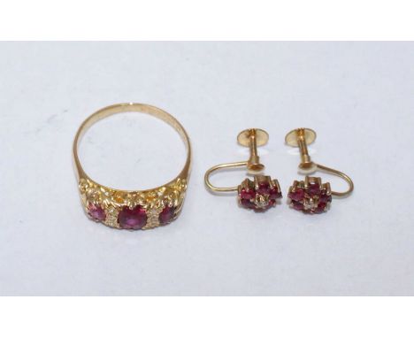 An Edwardian 18ct gold, ruby and diamond ring, the pierced scrolled head set with three graduated oval rubies interspersed wi