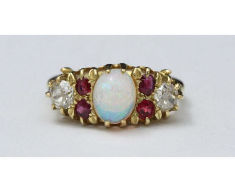 An antique 18ct gold diamond, opal and ruby ring, claw-set an oval opal, 7.45x6.42mm, flanked by four oval faceted rubies and