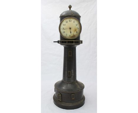 An early 20th century patinated sheet brass clock, modelled as a lighthouse, the white dial with Arabic numerals denoting hou