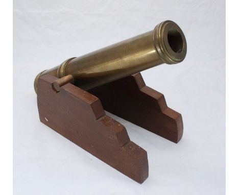 A scale model brass canon, tapering barrel with three rings, 40cm long, on wooden truck