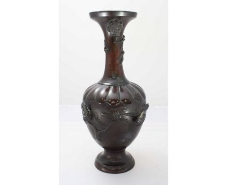 A late 19th Century Japanese patinated bronze baluster vase, cast with animal masks and birds amidst trees, 37cm high.