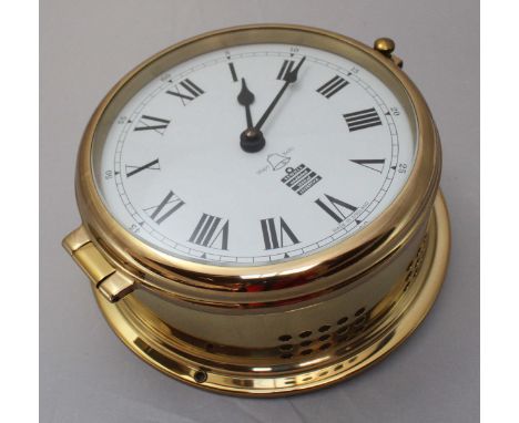 A Sewills brass bulkhead clock with quartz movement striking a bell, circular brass case, 19cm diam