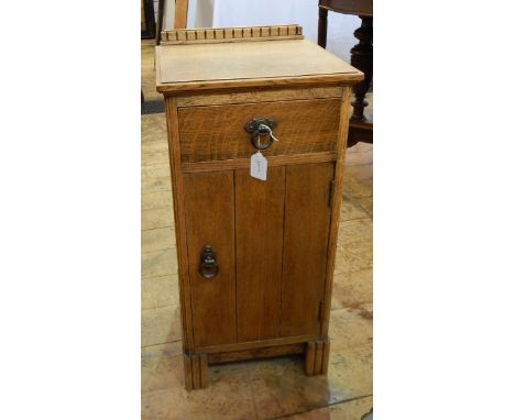 Oak side cabinet with dentil raised back single frieze drawer with circular handle and cupboard below, on shaped bracket feet