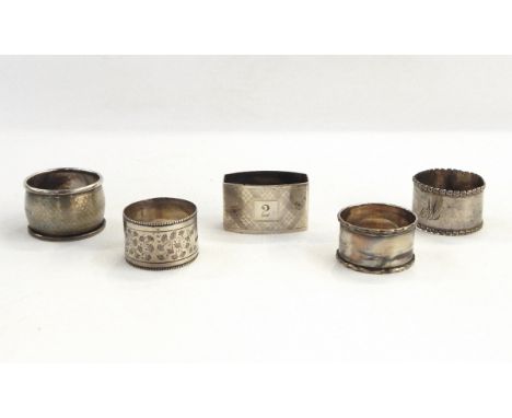 Five assorted silver napkin rings, one with engine-turned decoration and engraved 'Pam', another with floral decoration, etc.