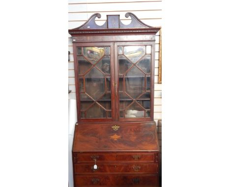 Georgian flame mahogany bureau bookcase, the top with swan neck pediment, urn and swag inlay, three shelves enclosed by astra