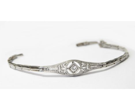 White gold and diamond bracelet set with a central brilliant cut diamond within a pierced surround with grain set diamond chi