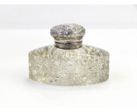 Edwardian silver-mounted glass inkwell, the cut glass body of oval form and the silver hinged cover with foliate decoration, 
