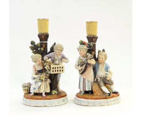 Pair early 19th century continental porcelain candlestick figure groups depicting boy and girl with garland of flowers and do