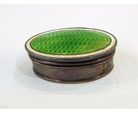 Silver and enamel pill box, Birmingham 1910 of oval form, the hinged cover with bright green enamel within a cream border, gi