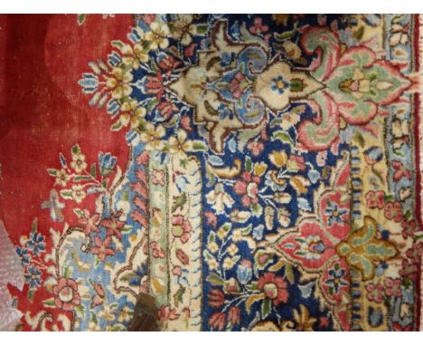 Persian wool carpet with red ground, floral arabesque decoration, blue borders, 380cm x 290cm 