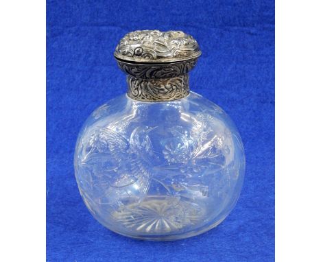 Silver mounted glass scent bottle, the embossed hinged cover by William Comyns, London, date mark rubbed, the glass body etch